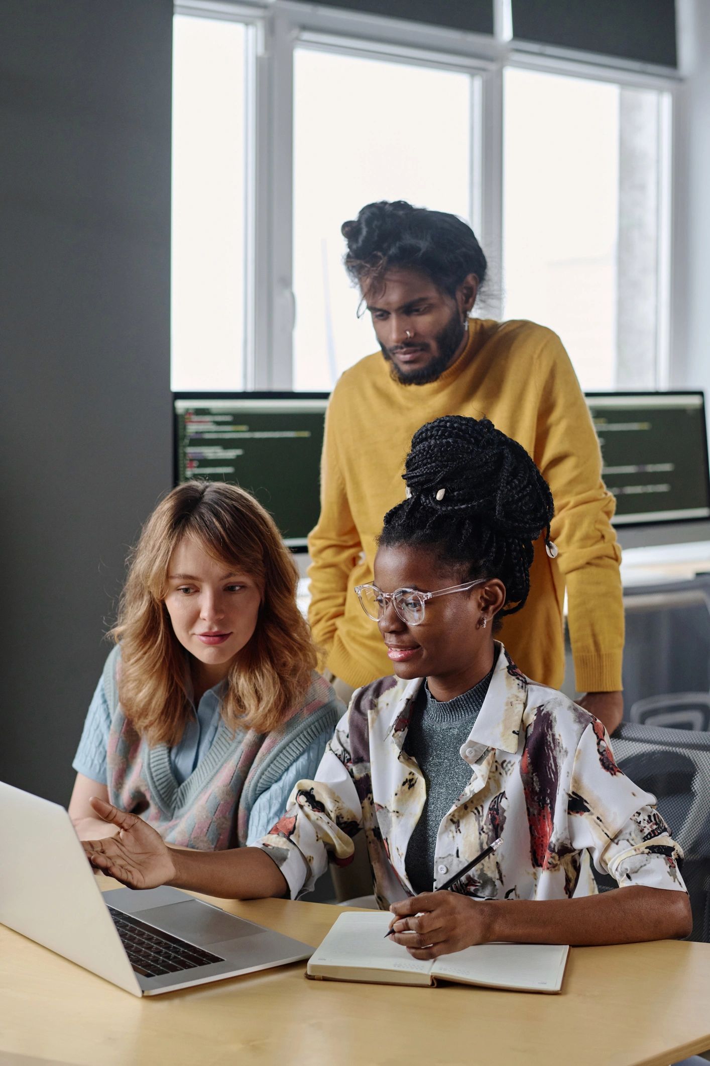 Workers reviewing job information together on a laptop